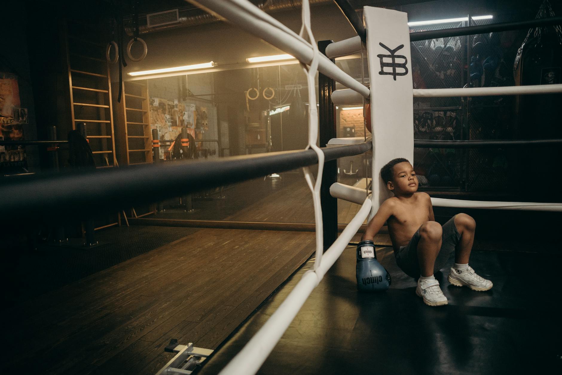 Młody bokser odpoczywa na ringu po wyczerpującym treningu