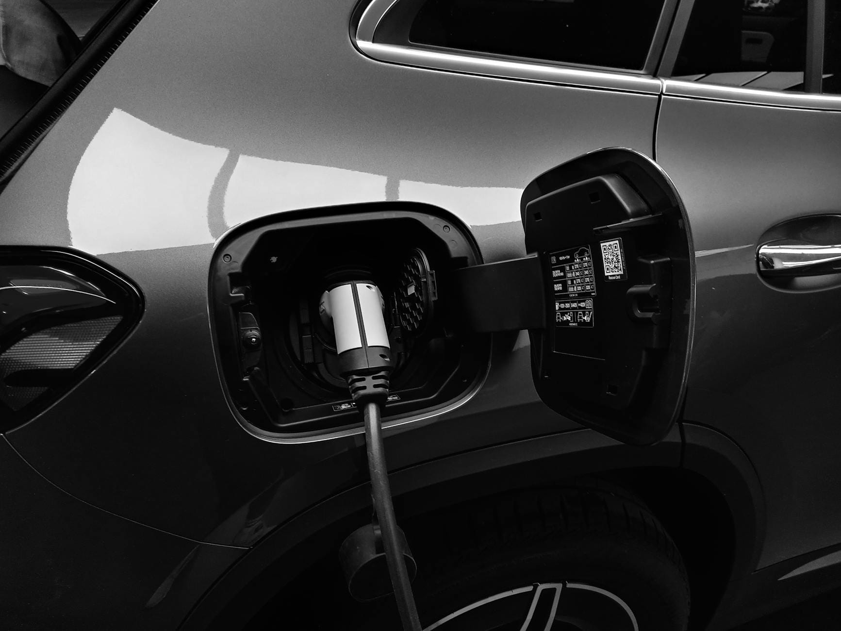 Zbliżenie na kabel ładowania podłączony do samochodu elektrycznego